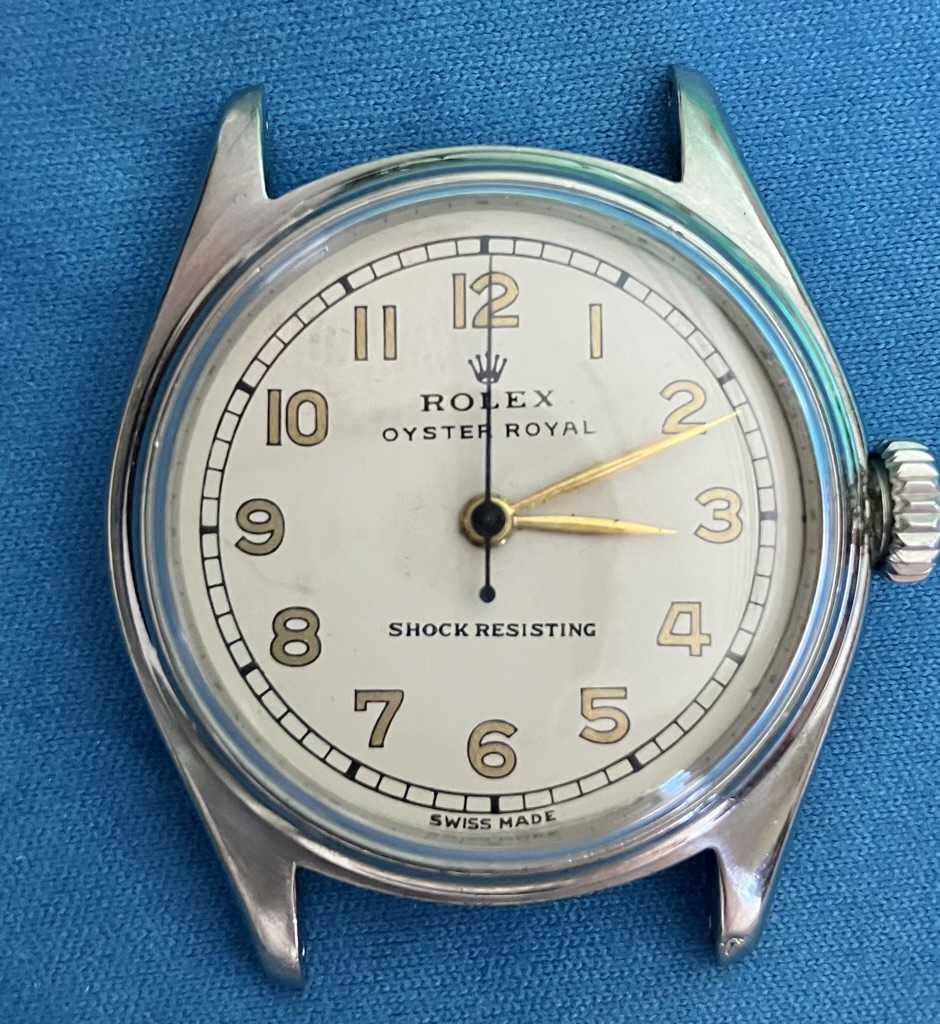 Close-up of a vintage Rolex Oyster Royal analog watch with white dial and gold numerals-Serviceing